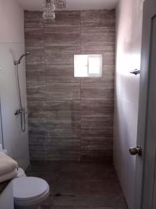 um banheiro com vaso sanitário e box de vidro em Harmonia - Sunbeha resort, Juan Dolio em Juan Dolio mais 12 fotografias