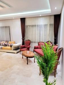 a living room with red chairs and a couch at 3BR Near Airport Secure,Equipped stay and transit in Nouaseur +38 photos