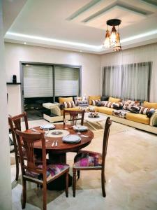 a living room with a table and chairs and a couch at 3BR Near Airport Secure,Equipped stay and transit in Nouaseur