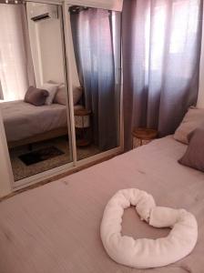 uma cama branca com uma toalha redonda em cima. em Harmonia - Sunbeha resort, Juan Dolio em Juan Dolio