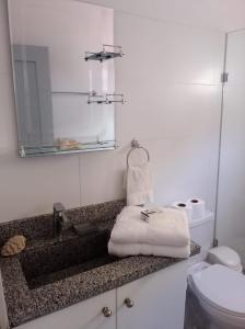 uma casa de banho com um lavatório, um espelho e um WC. em Harmonia - Sunbeha resort, Juan Dolio em Juan Dolio