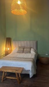 een slaapkamer met een bed met een tafel en een lamp bij Ruka Fusión in Carlos Keen