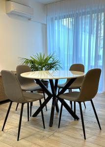 een eettafel met stoelen en een plant bij Vodno Apartment - Top location and private parking in Skopje