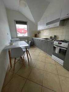 een keuken met een tafel en een tafel met stoelen bij Apartament Osielsko in Osielsko