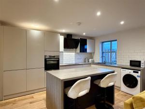 a kitchen with a counter and two chairs in it at Woodland View House in Norton Canon