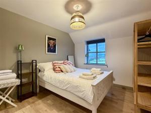 a bedroom with a bed with towels on it at Woodland View House in Norton Canon