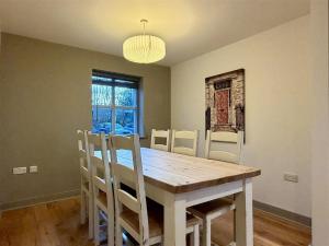 a dining room with a wooden table and chairs at Woodland View House in Norton Canon