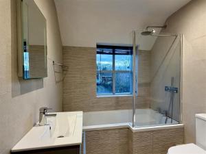 a bathroom with a tub and a sink and a shower at Woodland View House in Norton Canon +8 photos
