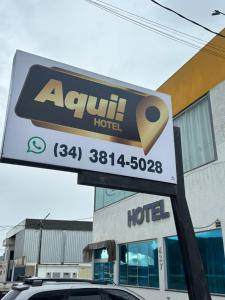 a sign for a hotel in front of a building at Aqui Hotel in Patos de Minas
