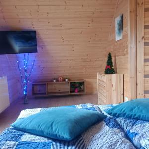 a bedroom with a bed with a television and a christmas tree at Domki Bursztyn in Święta Katarzyna