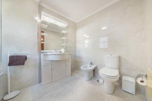 un bagno bianco con un water e un lavandino di Esmael Apartment By Mth a Funchal Altre 20 foto