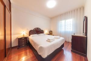 una camera da letto con un letto con lenzuola bianche e una finestra di Esmael Apartment By Mth a Funchal