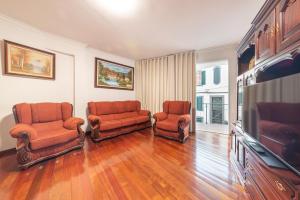 un soggiorno con due sedie e una TV a schermo piatto di Esmael Apartment By Mth a Funchal