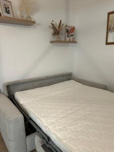 Appartement charmant au cœur de Saint-Rémy, idéal pour une escapade provençale ! في سان ريمي دو بروفنس: سرير في غرفه مرتبه بيضاء