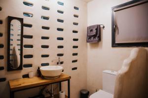 a bathroom with a toilet and a sink on a wall at Handmade semi basement in Ioannina +22 photos