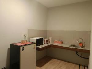 a small kitchen with a refrigerator and a microwave at Lanta Maikaew Guesthouse in Ko Klang