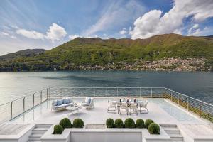 a boat with tables and chairs and a view of the water at Mandarin Oriental, Lago di Como in Blevio +117 photos