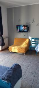 a living room with a couch and a flat screen tv at A Santy's House 1piano-no lift-raggiungibile a piedi aeroporto-fermata bus fiera di roma a 3 minuti-NO ANIMALI bed FOR A FEE A PAGAMENTO in Fiumicino