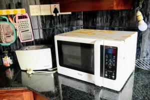 un microondas sentado en la parte superior de un mostrador en Accoma Villa, en Hikkaduwa