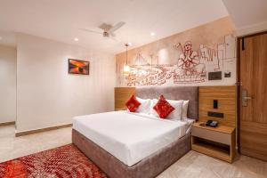 een slaapkamer met een groot bed en een schilderij aan de muur bij Klyra Hotel in Hyderabad