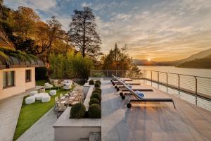 a group of tables on a patio with a view of the water at Mandarin Oriental, Lago di Como in Blevio