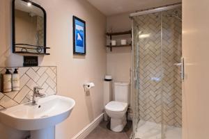 a bathroom with a sink and a toilet and a shower at The Three Swallows Cley in Cley next the Sea