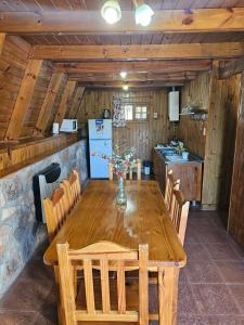 a kitchen with a wooden table with chairs and a refrigerator at Village in La Cumbrecita