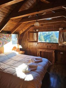 a large bed in a room with a large window at Village in La Cumbrecita