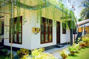 Un edificio con plantas a los lados. en Accoma Villa, en Hikkaduwa