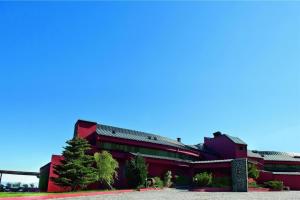 un edificio rojo con un árbol delante de él en Hotel Carqueijais - Serra da Estrela, en Covilhã