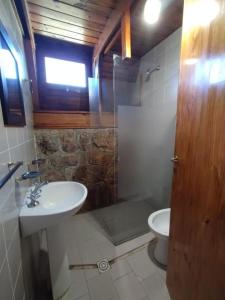 a bathroom with a sink and a toilet and a shower at Village in La Cumbrecita