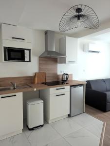 Una cocina con gabinetes blancos y encimera. en Le Nid des piétons - Hyper Centre, en Valence