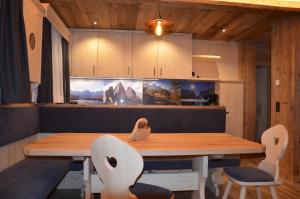 een eetkamer met een houten tafel en stoelen bij Kuenerhof in Versciaco di Sopra