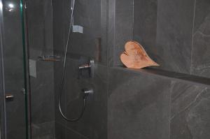 een douche met een glazen deur met een handdoek op een plankje bij Kuenerhof in Versciaco di Sopra