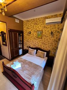 a bedroom with a large bed with yellow wallpaper at Antique Royal Hotel in Baku