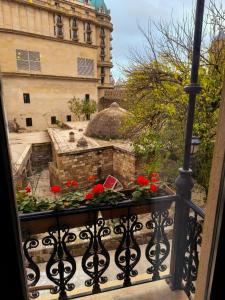 a balcony with a window with red flowers on it at Antique Royal Hotel in Baku