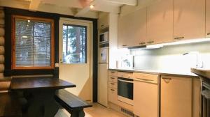 una cucina con tavolo al centro di Vuokatin Lomakämpät a Sotkamo