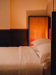 Un dormitorio con una cama blanca y un cabecero de madera. en Aethos Milan, en Milán