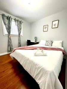 um quarto com uma cama grande com duas toalhas sobre ela em Cozy Queen room with Shared Bath near Seneca Finch 404 em Toronto