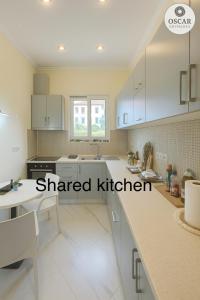 a kitchen with white cabinets and a white counter top at Oscar’s Apartments Drymades in Dhërmi