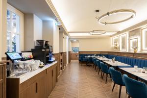 a dining room with long tables and blue chairs at BasiliQ Hotel in Budapest +51 photos