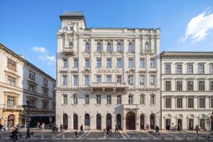 a large white building with people walking in front of it at BasiliQ Hotel in Budapest