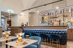 a restaurant with tables and chairs and a bar at BasiliQ Hotel in Budapest +50 photos