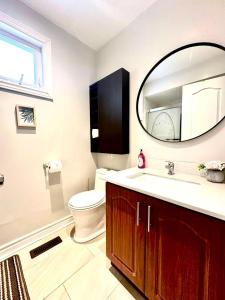 um banheiro com vaso sanitário e espelho em Cozy Queen room with Shared Bath near Seneca Finch 404 em Toronto mais 24 fotografias