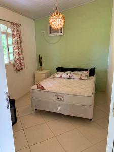 Chalé Suites Maresias في ساو سيباستياو: غرفة نوم بسرير وثريا