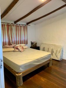 Chalé Suites Maresias في ساو سيباستياو: غرفة نوم بها سرير كبير في الغرفة