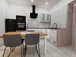 a kitchen with a wooden table and chairs at Vakantiehuis HA1 in Ieper