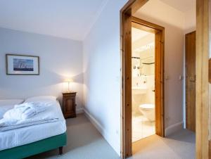 um quarto com uma cama e um banheiro com vaso sanitário em Strandhotel Strande em Strande
