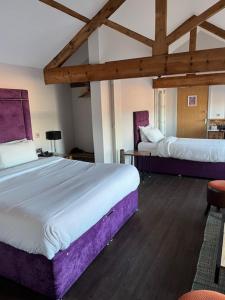 a bedroom with two beds with purple sheets at Hotel Forty One in Great Driffield