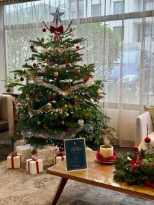 Un árbol de Navidad en una sala de estar con regalos. en Les Loges du Park, en Aix-les-Bains
